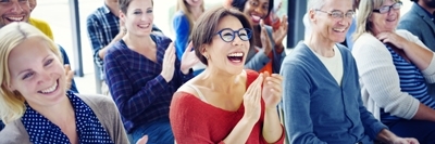 Inhouse Seminare - Frau klatscht Hände in einem Seminar